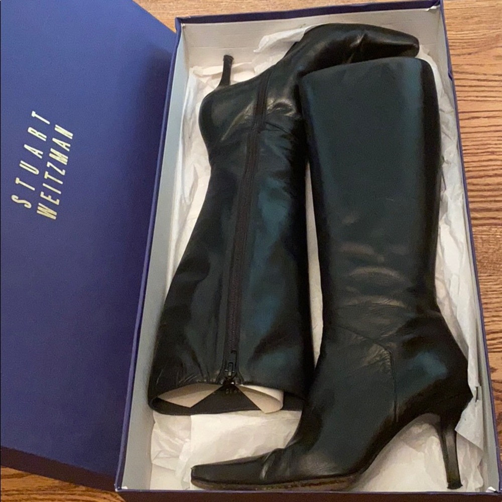 Black leather zip up tall boots. Beliow the knee.